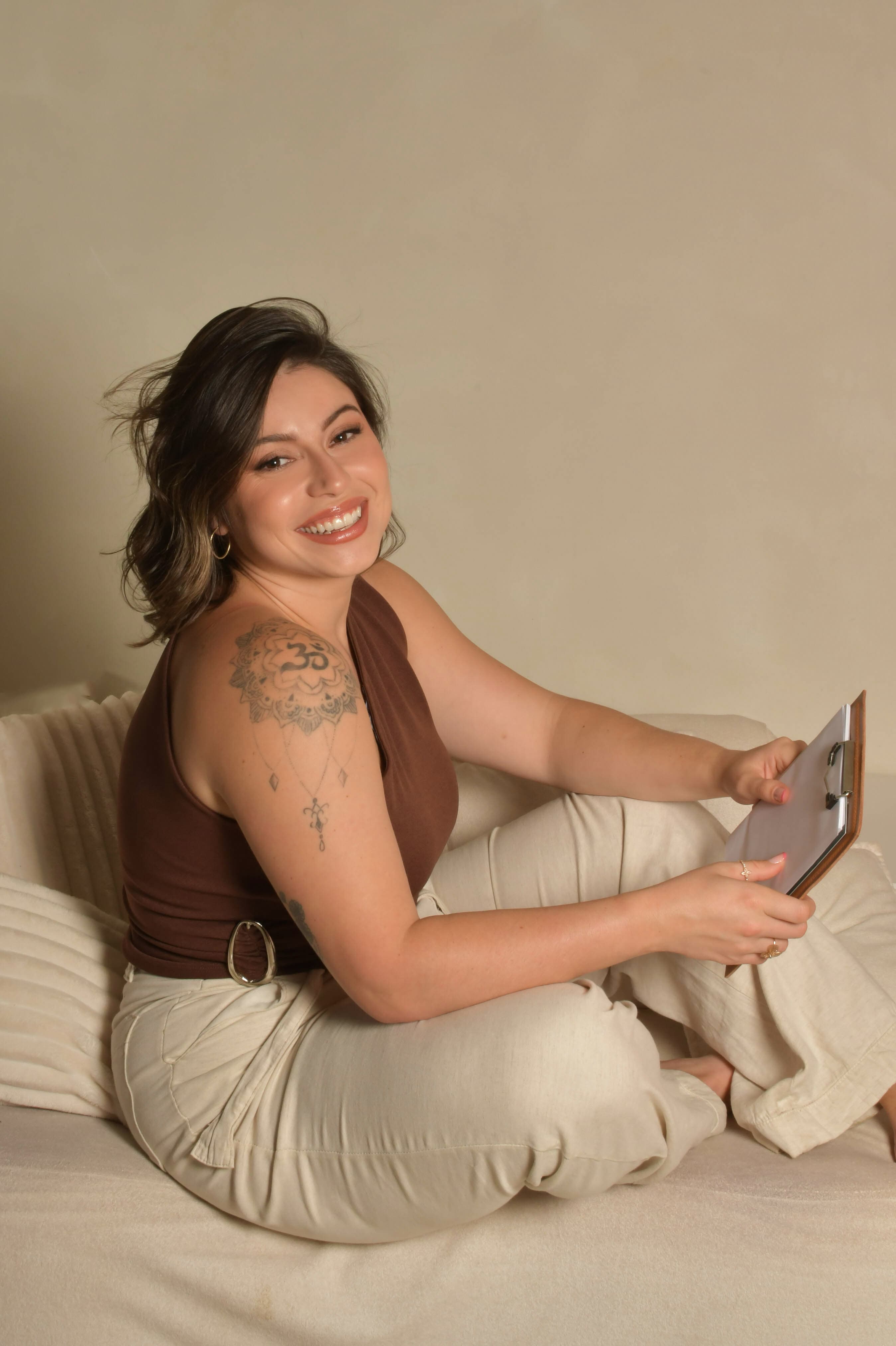 Tainá Gevaerd sorrindo com uma prancheta nas mãos